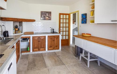 une cuisine avec des comptoirs blancs et des armoires en bois dans l'établissement Lovely Home In St, Maurice Sur Eygues, à Saint-Maurice-sur-Eygues