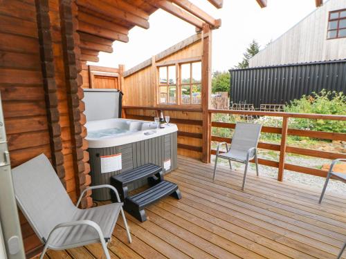 a deck with a hot tub and two chairs at Pheasant in Barnard Castle
