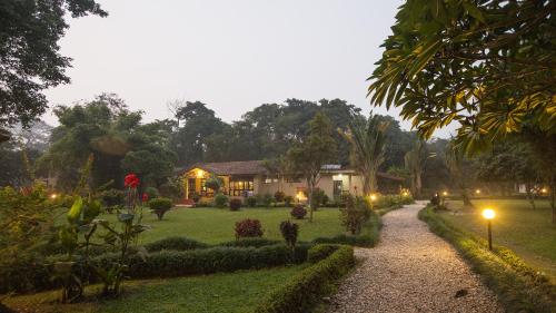 a house with lights in a garden at night at Green Mansions Jungle Resort in Sauraha
