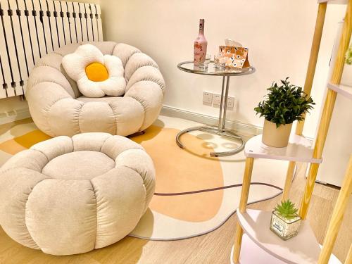 a living room with two chairs and a table at Mermaid's Secret-Bontique Homestay in Qingdao