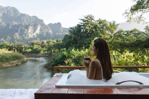 a woman sitting in a hot tub in a bath at Phu Siab Mhok@KhaoSok in Khao Sok