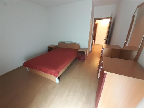 um pequeno quarto com uma cama vermelha num quarto em Apartman Nole 1 em Despotovac