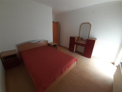 Un dormitorio con una cama roja y un espejo. en Apartman Nole 1, en Despotovac