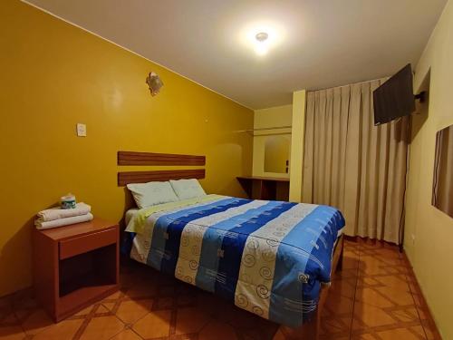 1 dormitorio con 1 cama y 1 mesa en una habitación en Hostal Cristal de luna, en Arequipa