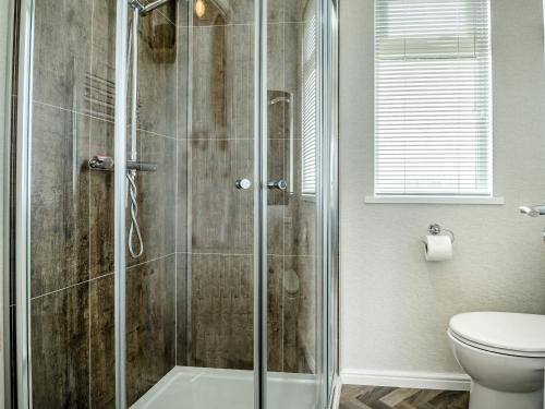a bathroom with a shower and a toilet at Number 8 Lakes View in Burnham on Sea