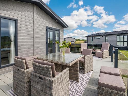 a patio with a glass table and chairs at Number 8 Lakes View in Burnham on Sea