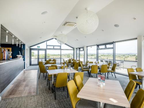 a restaurant with tables and chairs and windows at Number 8 Lakes View in Burnham on Sea