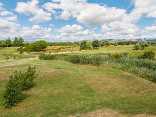 a view of a golf course with grass and trees at Number 8 Lakes View in Burnham on Sea