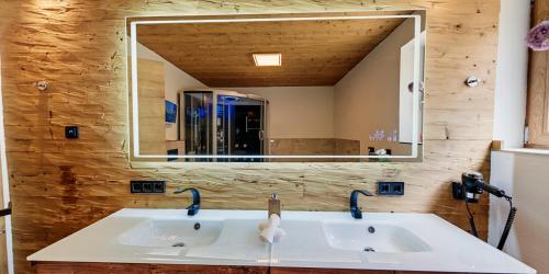 a bathroom with two sinks and a large mirror at Luxus Ferienwohnung Chalet Seenähe in Schalkenmehren