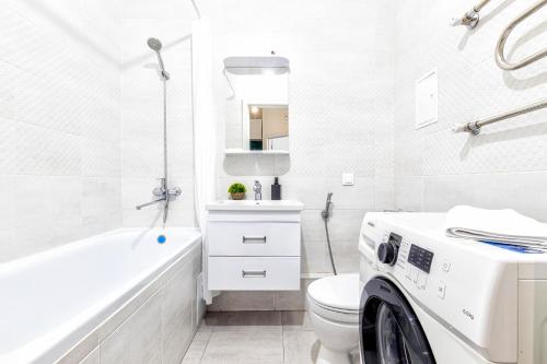 a white bathroom with a washing machine in it at Raisson Ahotel H252 in Taldykolʼ