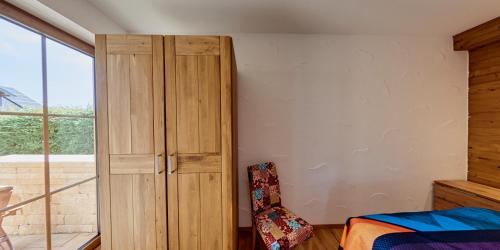 a bedroom with a wooden cabinet and a bed at Luxus Ferienwohnung Chalet Seenähe in Schalkenmehren