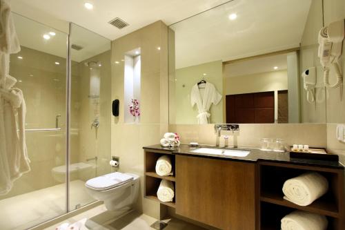 a bathroom with a toilet and a sink and a shower at Hotel Express Towers in Vadodara