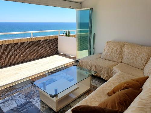 sala de estar con sofá y mesa de cristal en Ático frente al mar. Apartamento TOP, en Oropesa del Mar