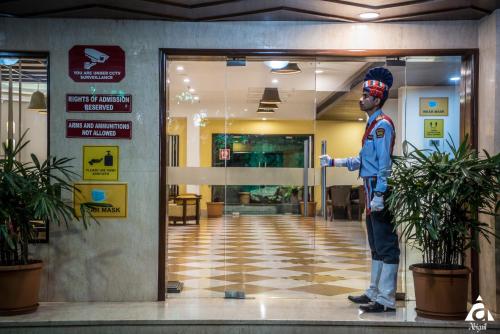 a statue of a man standing in front of a building at Hotel Abigail Goradia's in Shirdi