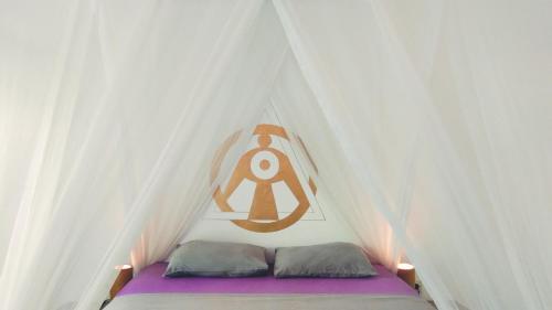- un lit dans une tente avec un panneau dans l'établissement Café des Arts Gili Air, à Gili Air