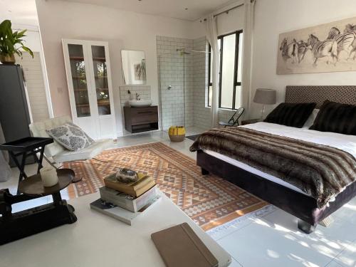 1 dormitorio con 1 cama grande y baño en PepperTree Guest House, en Johannesburgo