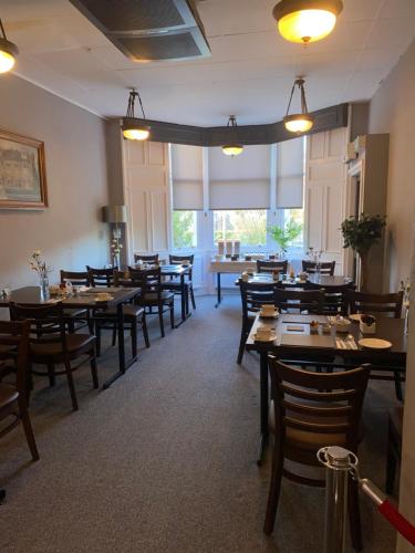 une salle à manger avec des tables et des chaises en bois dans l'établissement Ellwyn House, à Édimbourg