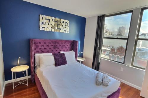 a bedroom with a large bed with a purple headboard at The Funky 2bd Apartment next to the convention center and reading terminal in Philadelphia