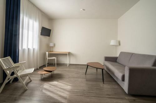 a living room with a couch and a table at Hotel Agaró in Chipiona