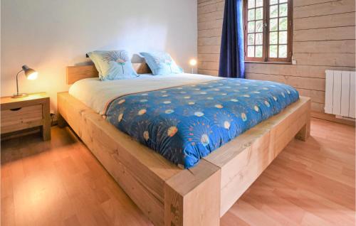 Un dormitorio con una cama de madera con una manta azul. en Stunning Home In Cormeilles With Kitchen en Cormeilles