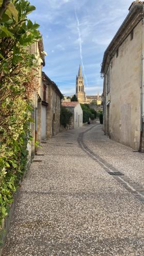 an empty street with a church in the background at La Maison du Clocher in Saint-Émilion