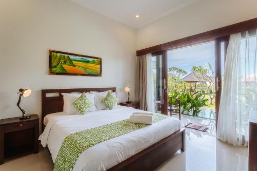 Tempat tidur dalam kamar di Carik Bali Guest House Canggu