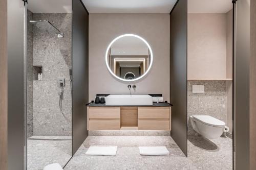 ein Bad mit einem Waschbecken und einem Spiegel in der Unterkunft Hotel Weisses Lamm in See