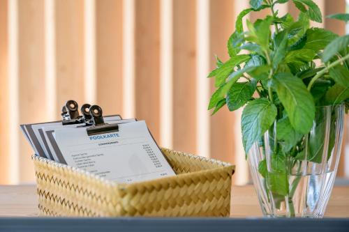 a basket with a book and a vase with a plant at Hotel Weisses Lamm in See
