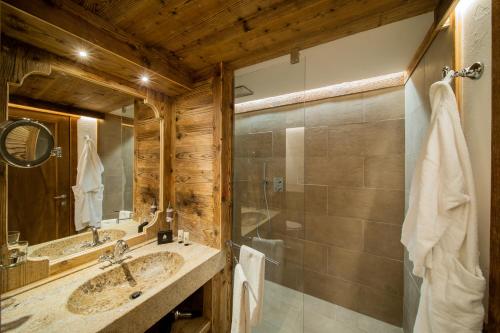 a bathroom with two sinks and a shower at Gran Baita Hotel & Wellness in Courmayeur