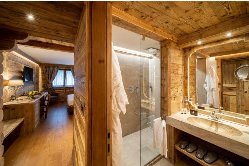a bathroom with a glass shower and a sink at Gran Baita Hotel & Wellness in Courmayeur