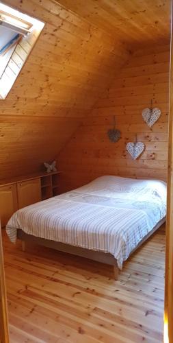 une chambre avec un lit dans une cabane en bois dans l'établissement Chalet au cœur du Val d'Azun, à Arras-en-Lavedan
