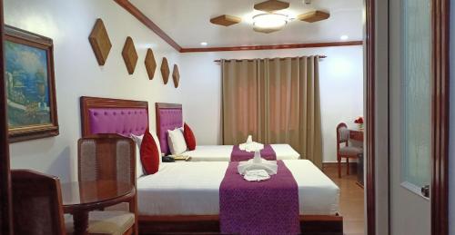 CLN Boutique Hotel في تاكلوبان: غرفة فندقية بسريرين وطاولة