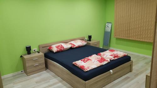 een slaapkamer met een bed met kussens erop bij Апартамент за гости Ива in Ruse