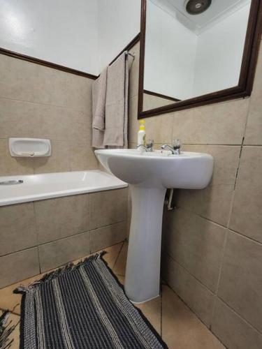 a bathroom with a sink and a mirror and a tub at Elegant 2 bed apartment next to Gautrain Centurion in Centurion