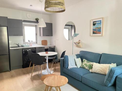un salon avec un canapé bleu et une cuisine dans l'établissement Avignon pedestrian area, charming, 4 persons, à Avignon