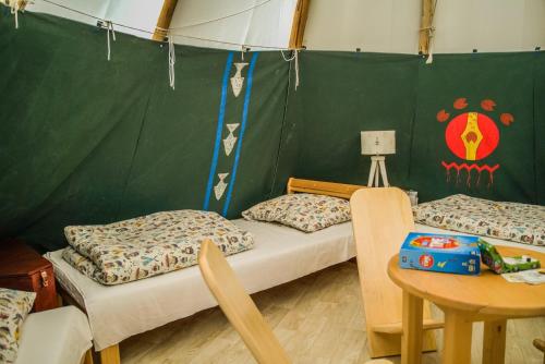 Pokój z dwoma łóżkami i stołem w obiekcie Wioska Indiańska River Park w Zatorze