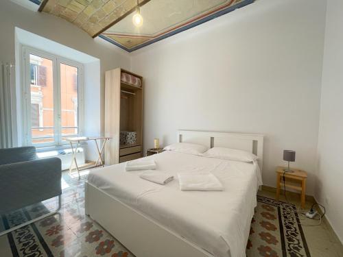 biała sypialnia z dużym łóżkiem i dwoma ręcznikami na nim w obiekcie CAIROLI BOUTIQUE APARTMENT w Rzymie