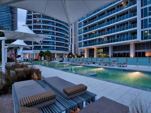 a swimming pool with lounge chairs and a building at LUXURY APARTMENT- with WATER VIEWS FROM EVERY DIRECTION in Gold Coast
