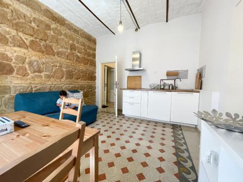 dziecko siedzące na niebieskiej kanapie w kuchni w obiekcie CAIROLI BOUTIQUE APARTMENT w Rzymie
