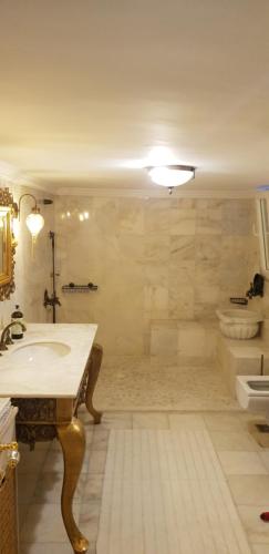 uma grande casa de banho com um lavatório e uma banheira em Konyaaltı plajına 10 dakika kral dairesi em Antalya