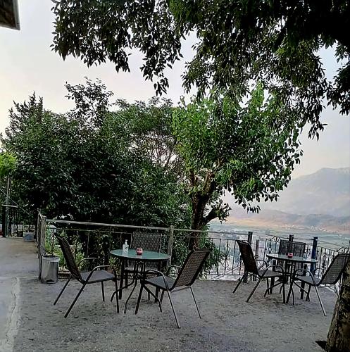 a group of tables and chairs with a view of the water at Panoramic Vlachos in Gjirokastër