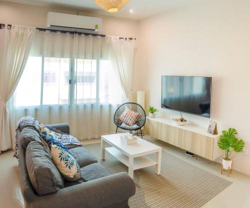 Il comprend un salon doté d'un canapé et d'une télévision à écran plat. dans l'établissement 100sqm 2 bed apartment Sukhothai City, à Sukhothaï