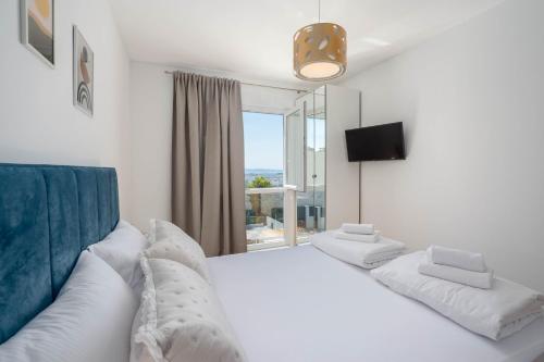 a bedroom with a large white bed and a window at Villa Dorso with heated pool in Klis