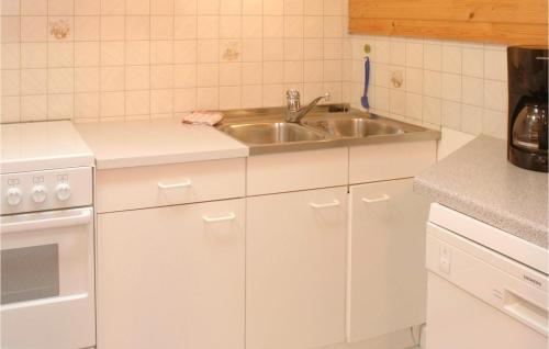 - une cuisine avec des placards blancs et un évier dans l'établissement Lovely Apartment In St, Gallenkirch With Kitchen, à Aussersiggam