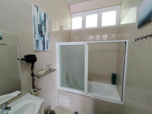 a bathroom with a shower and a toilet and a sink at Hotel Kimberly Tagaytay in Tagaytay