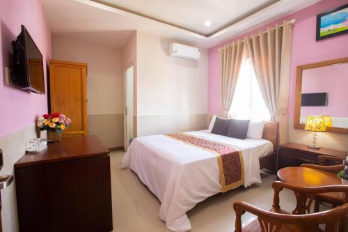 1 dormitorio con 1 cama, escritorio y TV en Hoang Anh Star Hotel en Ho Chi Minh