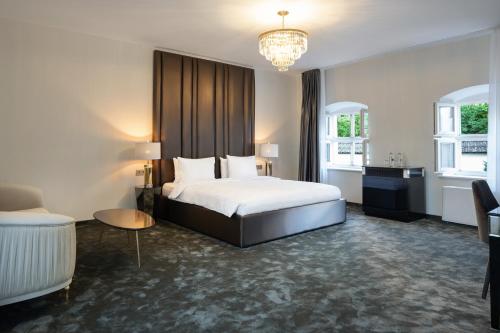 a hotel room with a bed and a chandelier at St Palace Hotel in Vilnius
