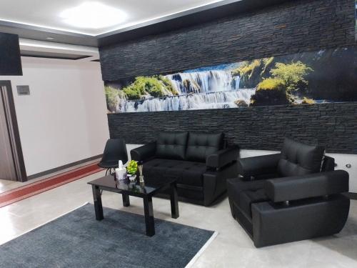 a living room with two black couches and a table at Konak kod Hame in Bihać
