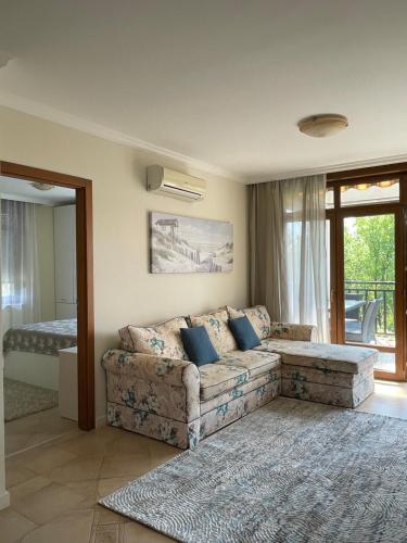 a living room with a couch and a bedroom at Апартамент в Созопол in Sozopol