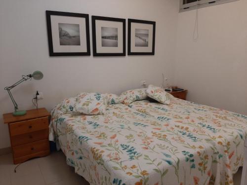 - une chambre avec un lit et trois photos sur le mur dans l'établissement Laluna, à La Laguna